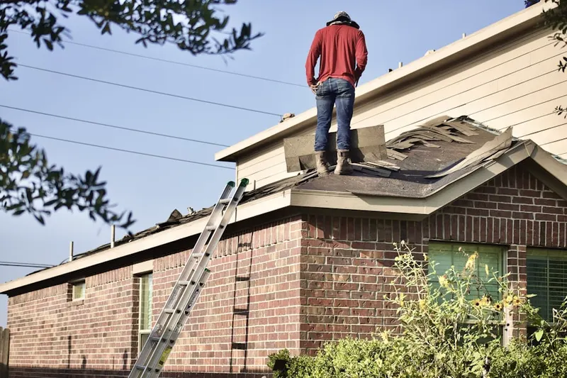 Professional roofer working on a residential roof in West Simsbury